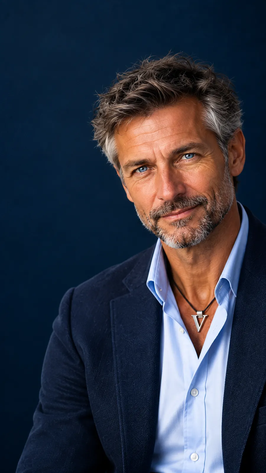 Ritratto istituzionale di Mister Visio: giacca blu notte, camicia chiara, sguardo calmo e mezzo sorriso